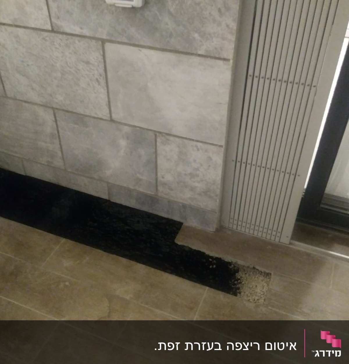 אזור אטום עם חומר שחור ליד קיר אבן